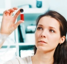 Laboratory assistant with blood sample in test tube