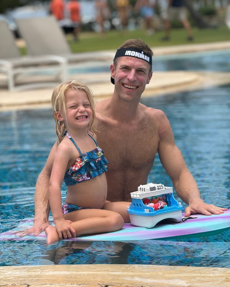 Dr. Josh Axe, fully recovered, in a pool with his daughter