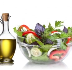glass bowl of Salad and oil on the side