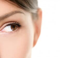 Eye close up - brown eyes looking to side isolated on white back