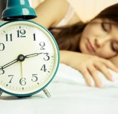 woman sleeping peacefully in bed, alarm clock