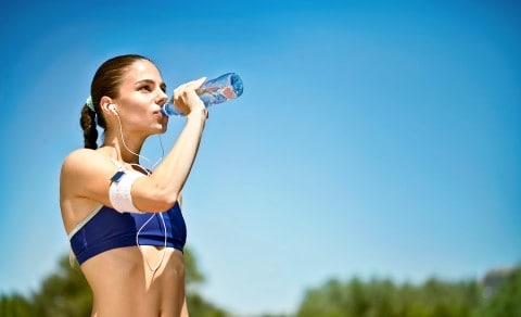 Athlete runner drinking water 