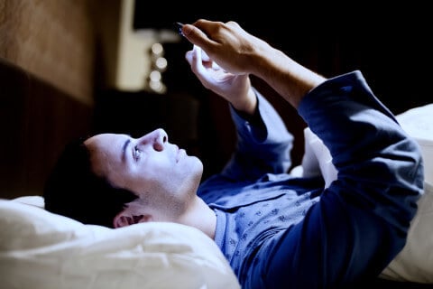 Man using mobile phone in bed